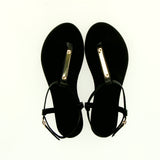 Black flip-flop sandal with strap and gold accessory