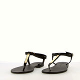 Black flip-flop sandal with strap and gold accessory