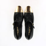 Black leather strap shoe with gold toe